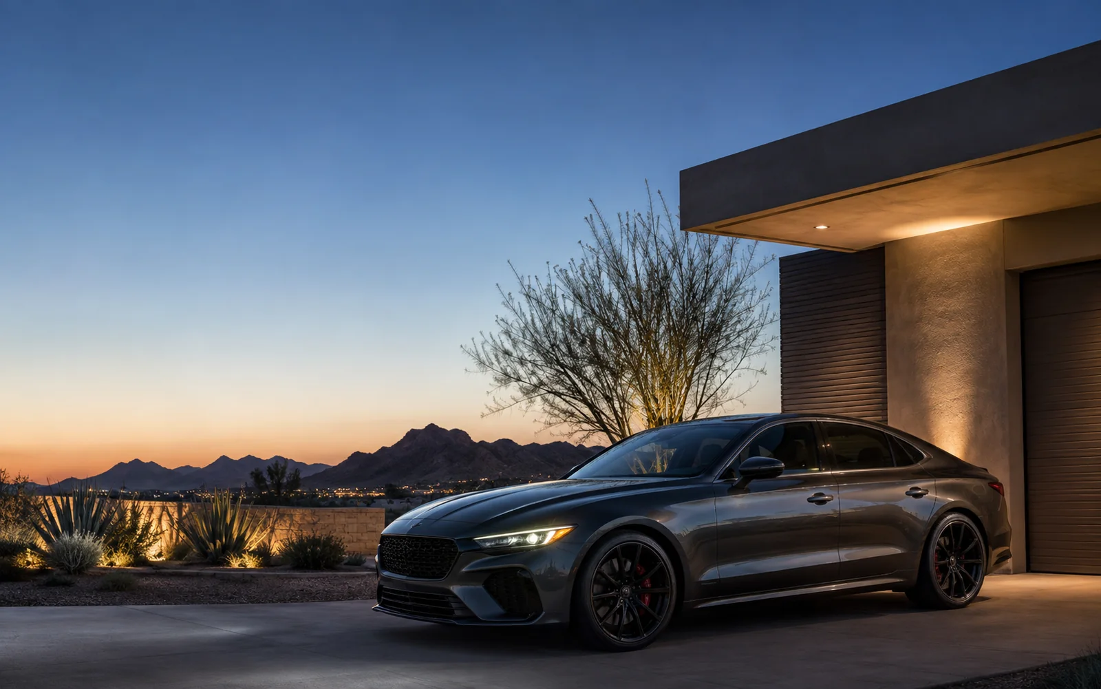 Graphite performance sedan beside a desert-modern Scottsdale home at blue hour.